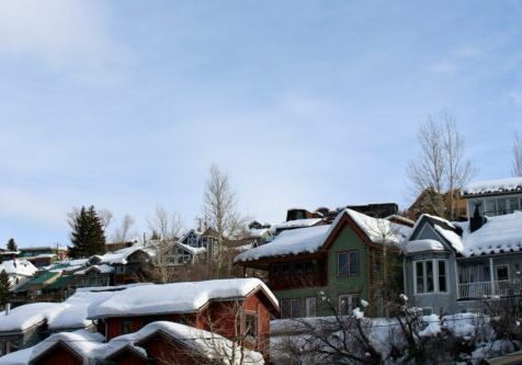 a group of houses covered in snow under a blue sky